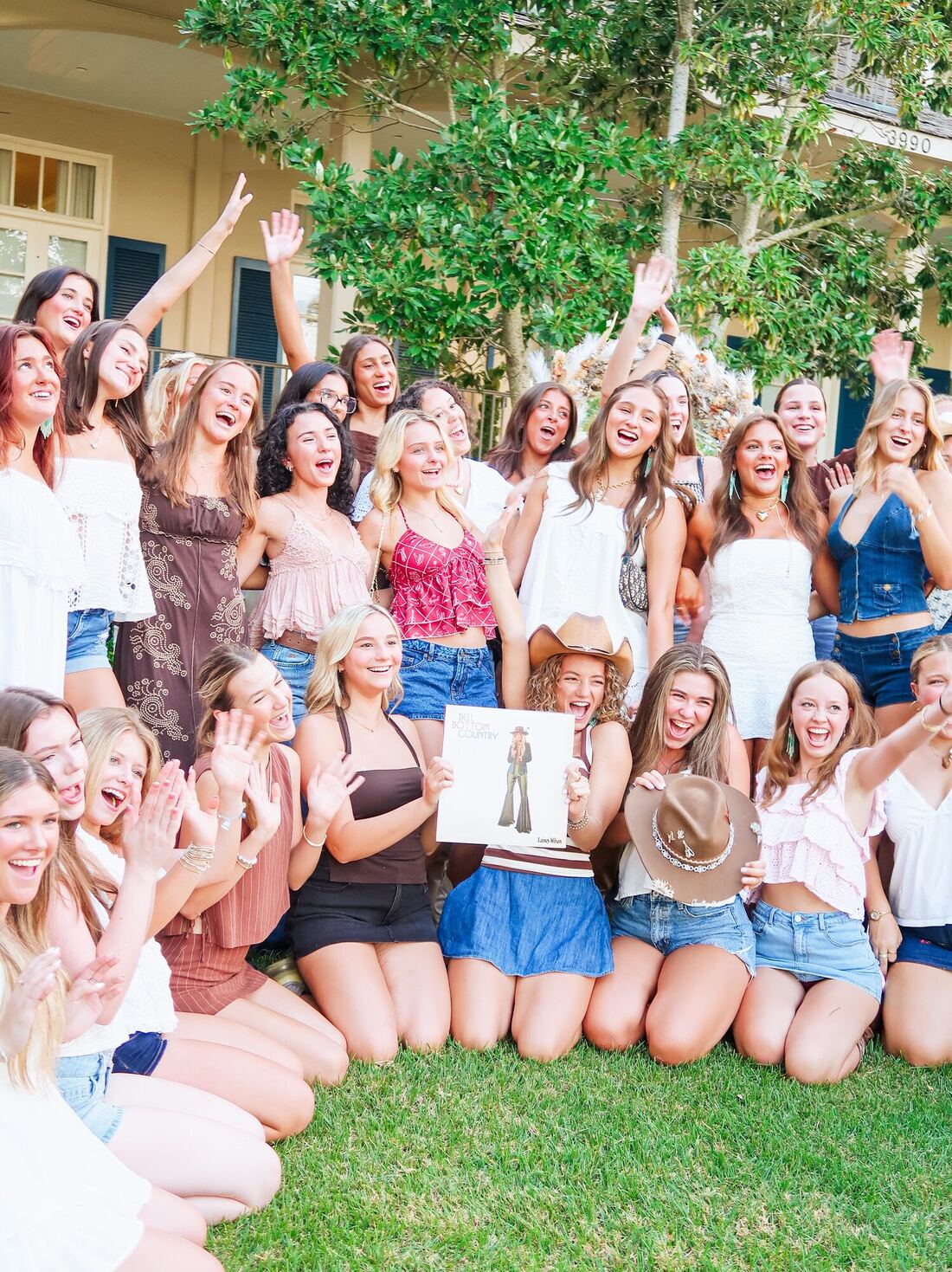 Alpha Delta Pi members cheering at the pop-up, one holding a Lainey Wilson “Bell Bottom Country” record